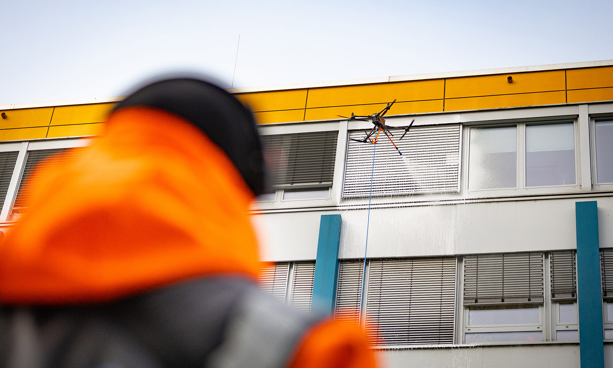 EIne Drohne von Skyfix reinigt ein Gebäude